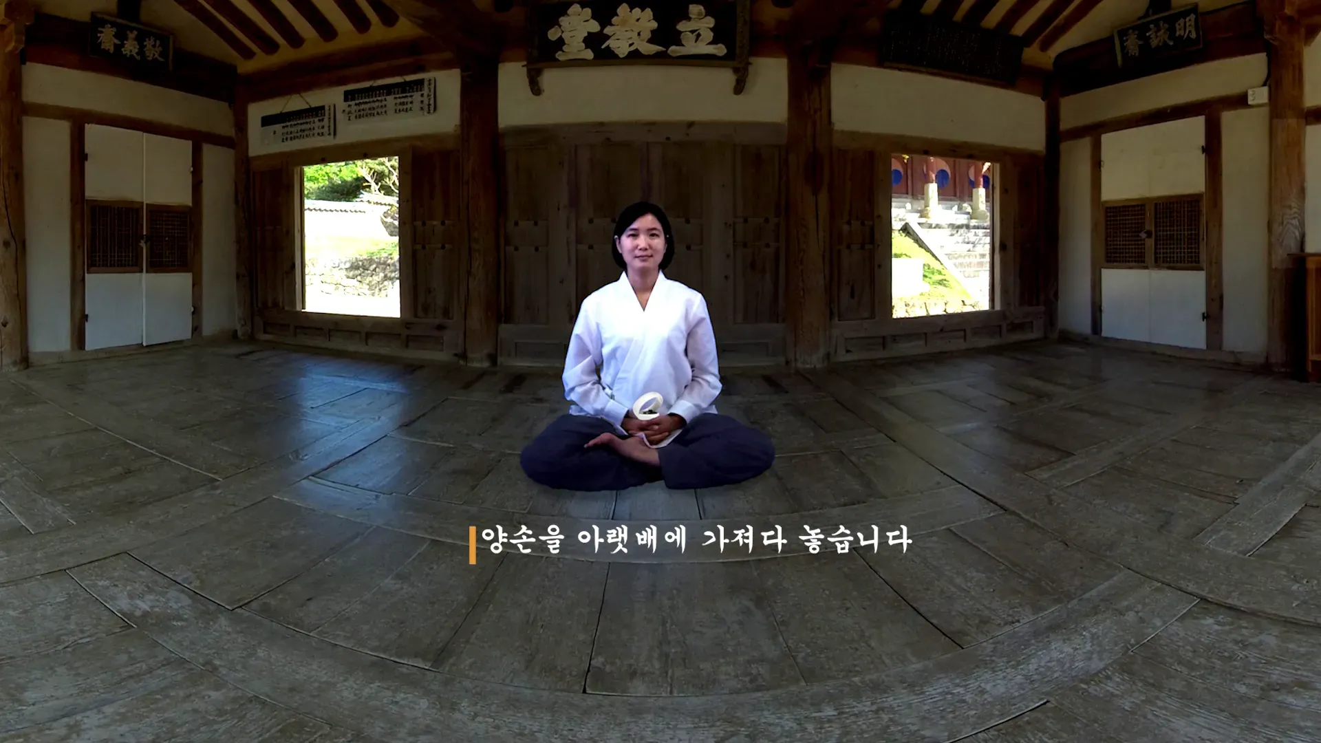 SEON — a meditating guide in a traditional Korean hall, with Korean breathing instructions on screen